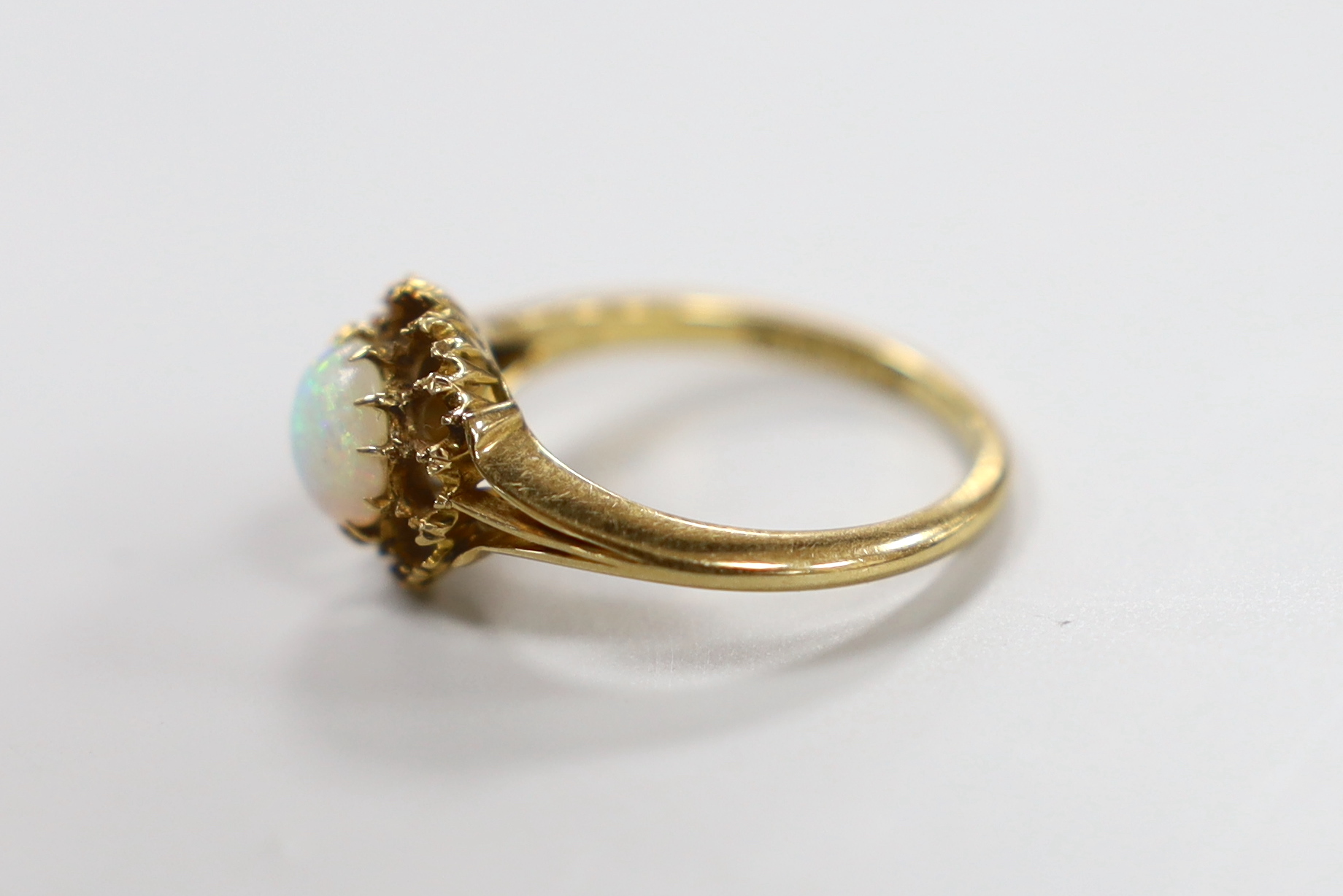 A late Victorian and single stone white opal set ring, size O/P, gross weight 3.9 grams (border stones missing).